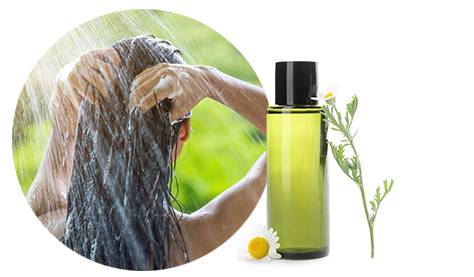 Frau wäscht ihr Haar mit Naturshampoo mit Kamille ohne Zusatzstoffe wie SLS oder SLES